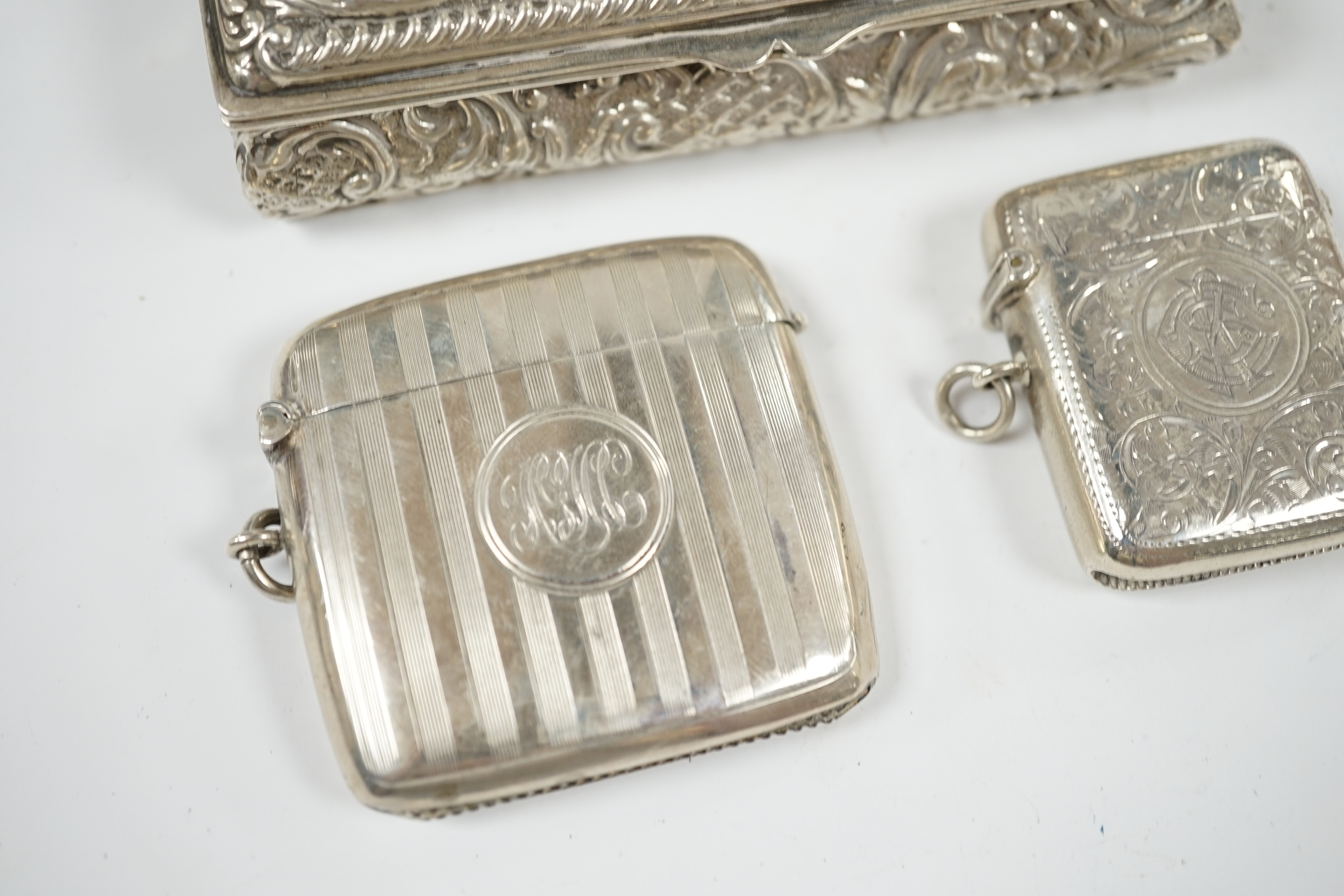 Two early 20th century silver vesta cases and an Edwardian repousse silver trinket box, 11cm. Condition - fair